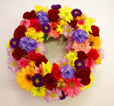 COLOURFUL WREATH - A respectful wreath fashioned from brightly-coloured flowers. The wreath can lie flat or stand upright.<br><br>Code:036-5392-036-0000076785
